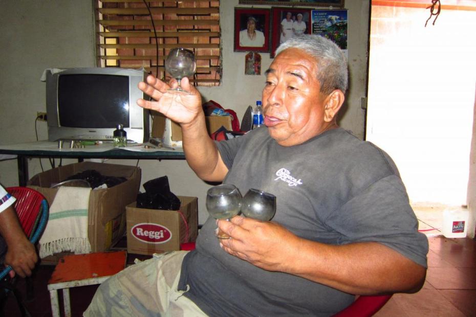 Alonso Garcia, majordomo of the Cofradía Padre Eterno, holds up cups for drinks for the last day of the year.